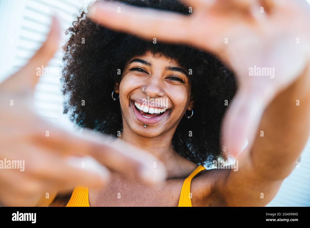 Felice giovane donna con finger frame Foto Stock