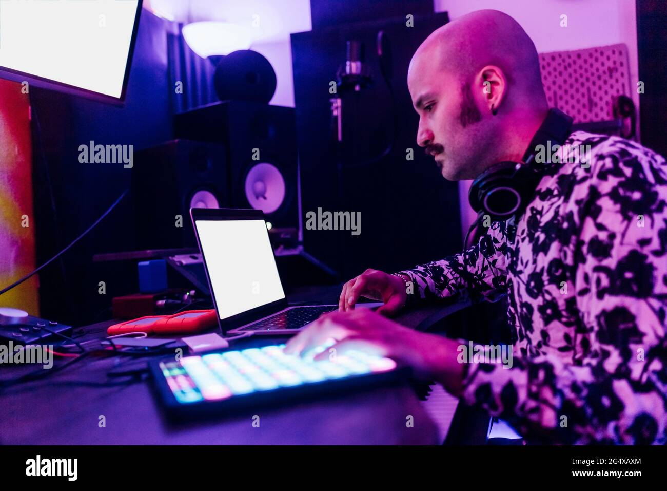 Compositore di musica maschile che usa un computer portatile in casa studio Foto Stock