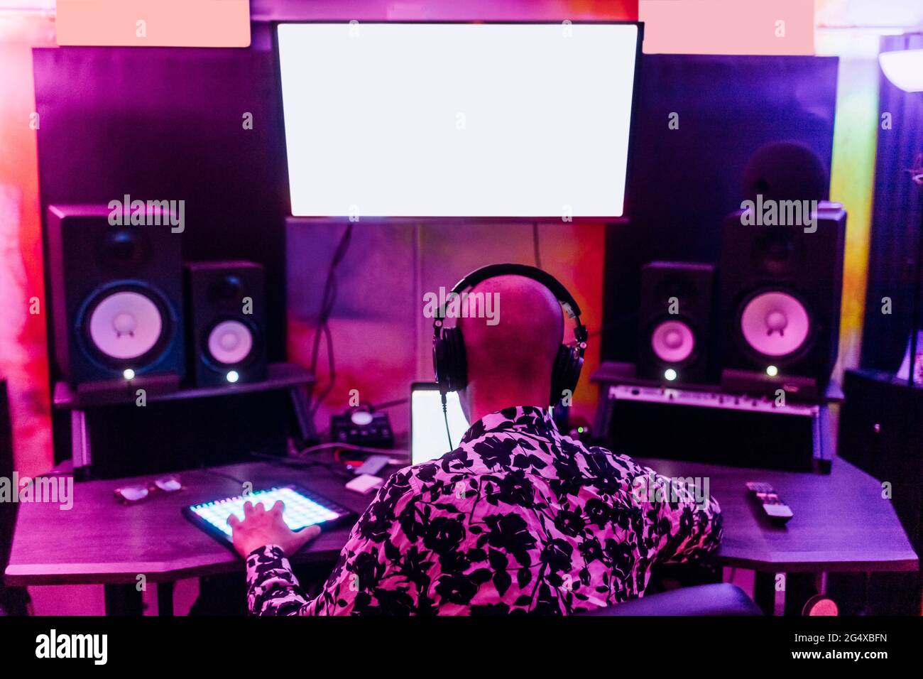 Uomo che indossa cuffie che compongono musica in studio Foto Stock