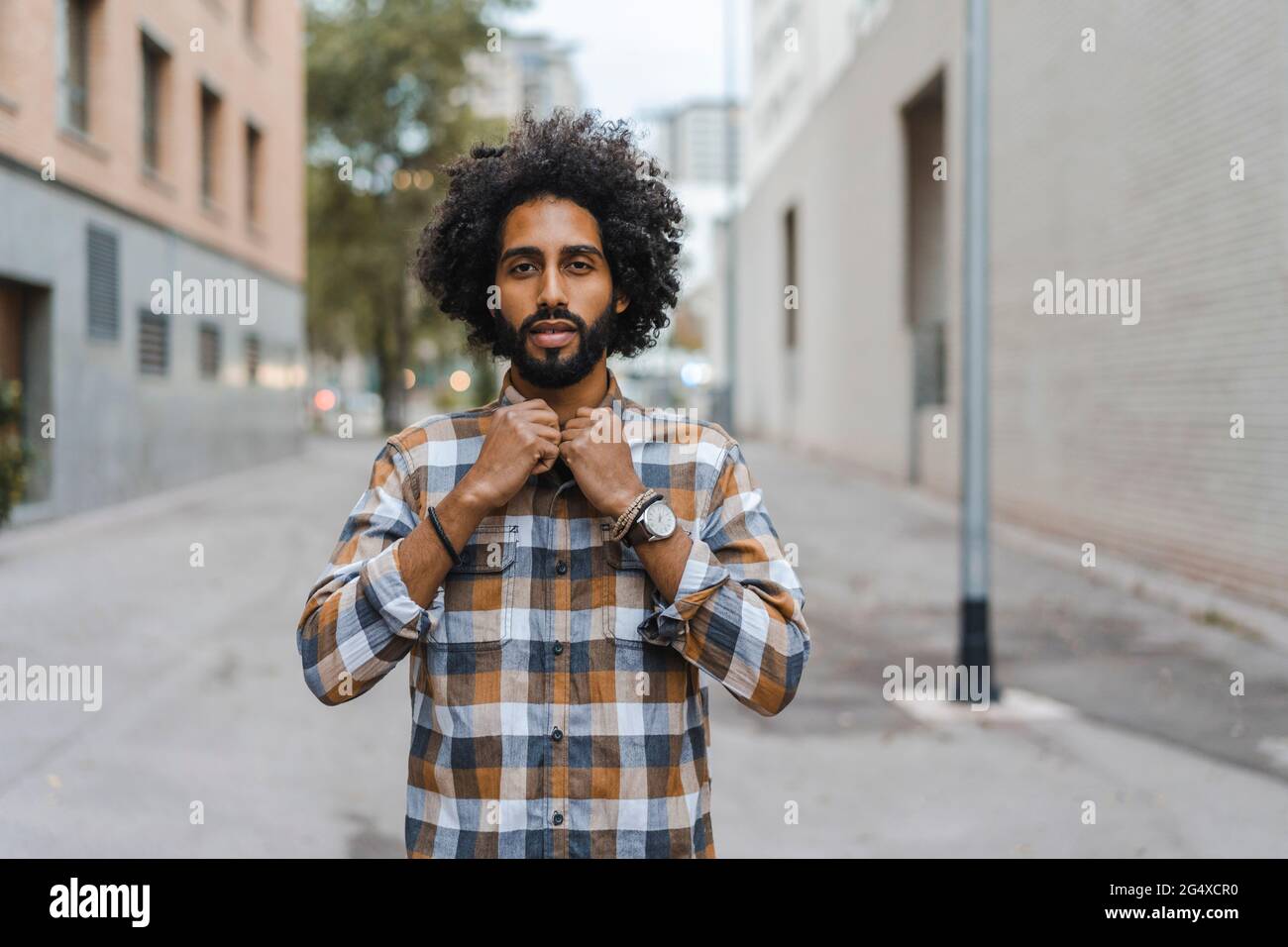 Uomo che abbottonava la camicia mentre si sta sul sentiero Foto Stock