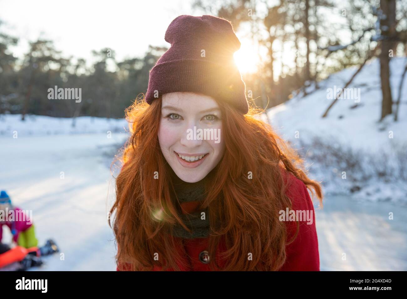 Donna sorridente che indossa un cappello a maglia durante l'inverno Foto Stock