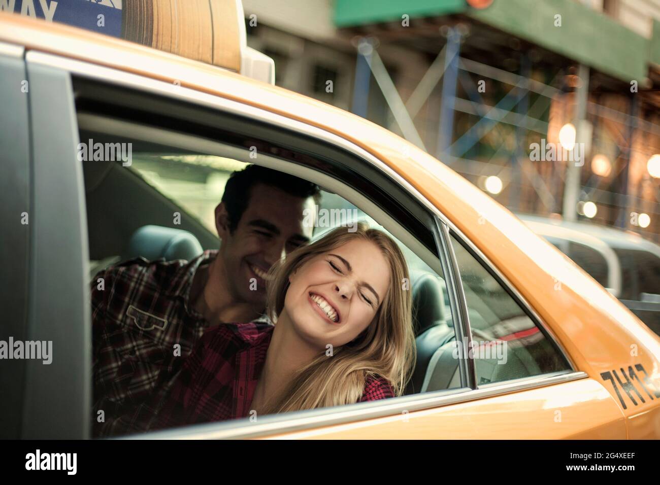 Ragazza felice con il ragazzo che viaggia in taxi Foto Stock