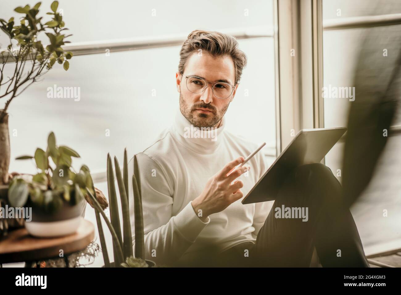 Uomo d'affari attento con tablet digitale su casa galleggiante Foto Stock