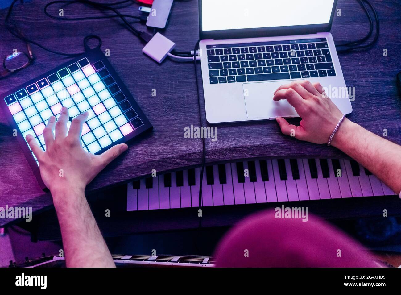 Uomo che usa tablet e computer portatile digitali mentre componi musica in studio Foto Stock