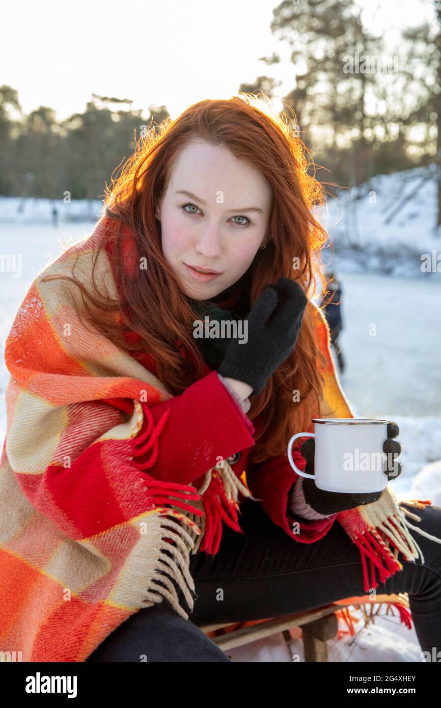 Bella donna che tiene tazza di caffè durante l'inverno Foto Stock
