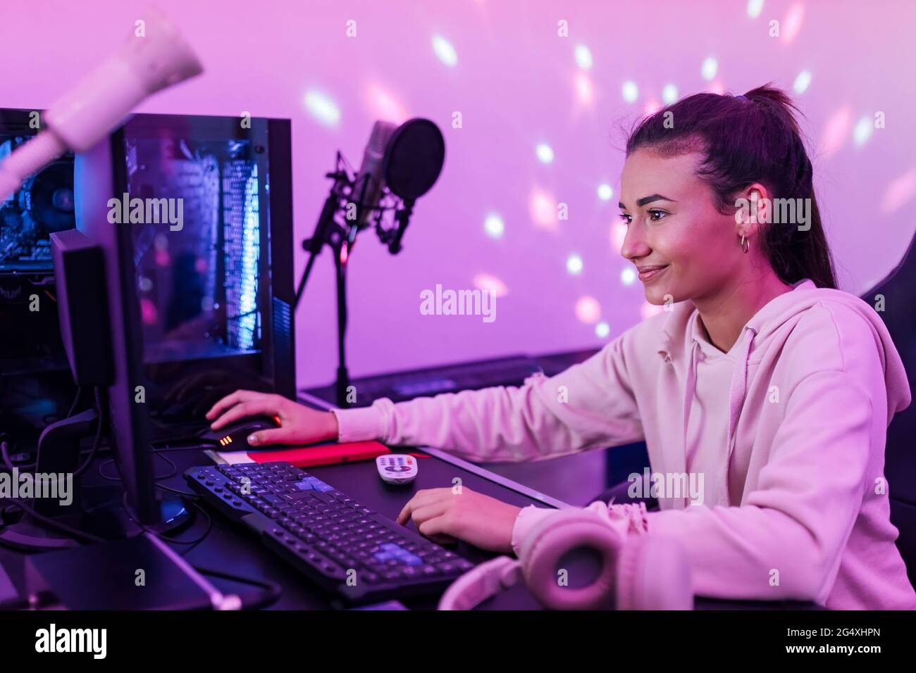 Sorridente cantante femminile che usa il computer in studio Foto Stock