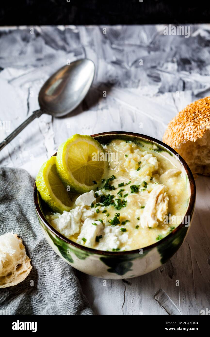 Ciotola di zuppa GreekÂ avgolemonoÂ con riso, fette di limone e pane Foto Stock