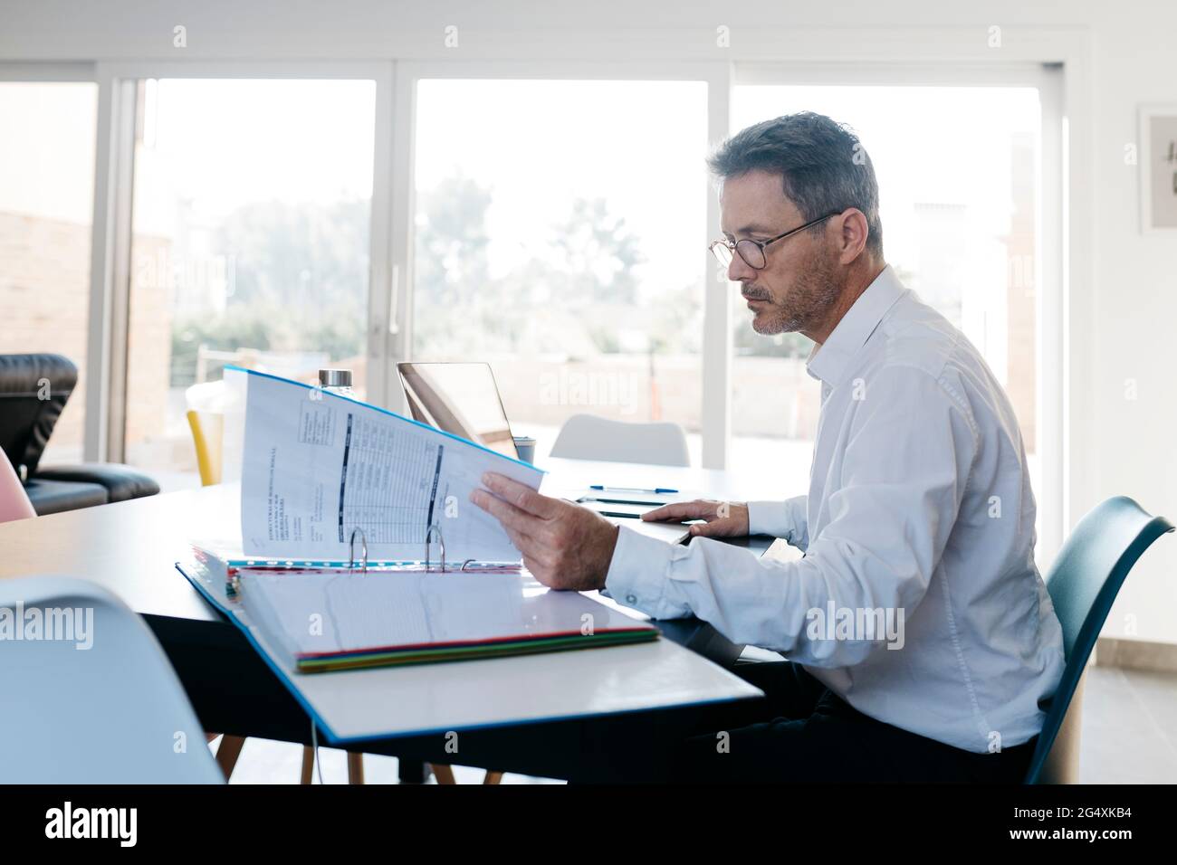Lavoratore freelance maschio che cerca i dati in file di scatola in ufficio domestico Foto Stock