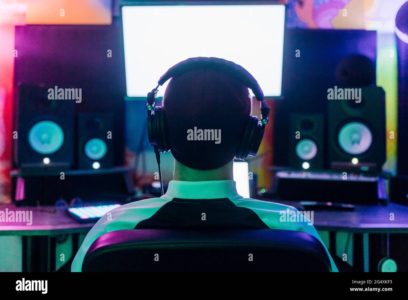 Compositore maschile che ascolta la musica mentre componi in studio a casa Foto Stock