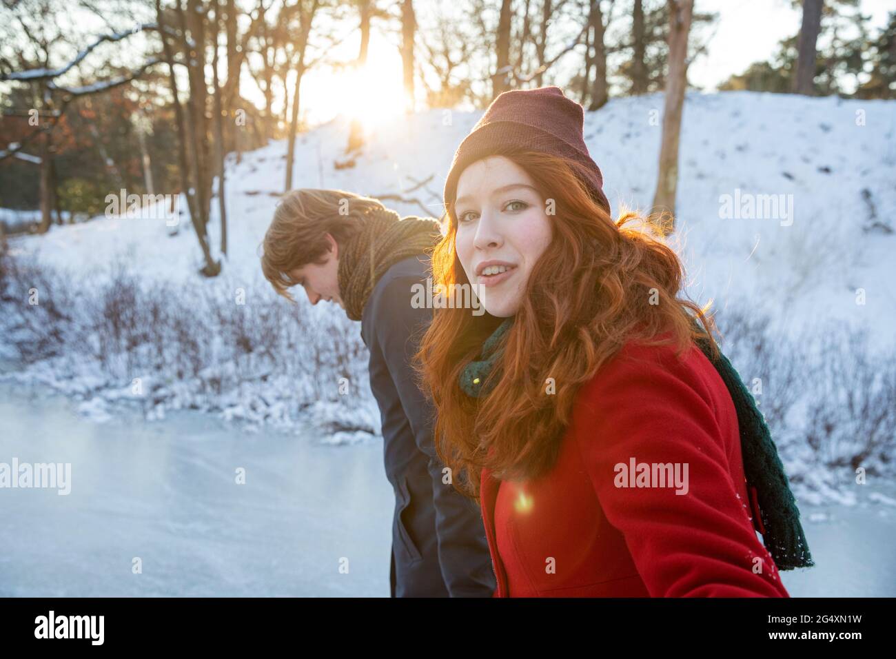 Donna rossa che cammina con il ragazzo sulla neve Foto Stock