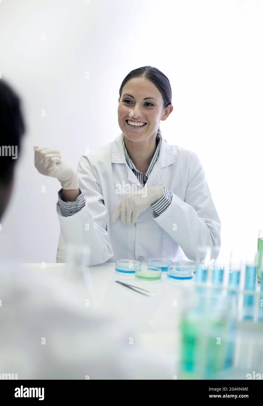 Sorridente tecnico di laboratorio che lavora con un collega in laboratorio Foto Stock