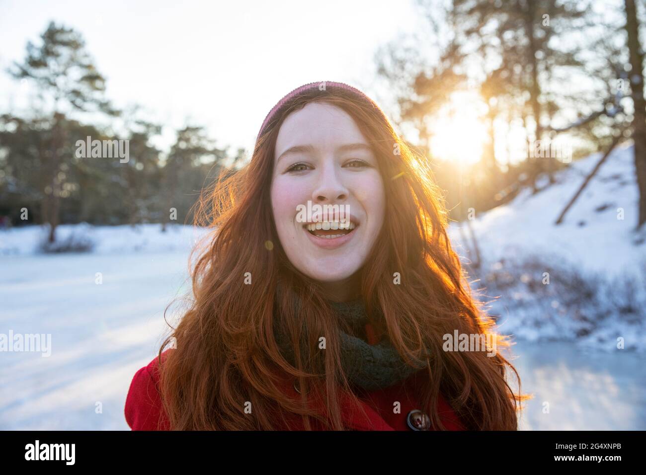 Donna sorridente rossa durante l'inverno Foto Stock