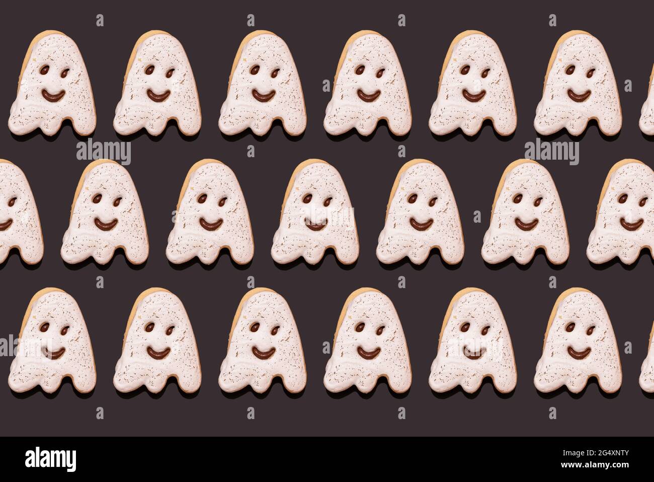 Modello di biscotti al cioccolato a forma di fantasma piatto su sfondo nero Foto Stock