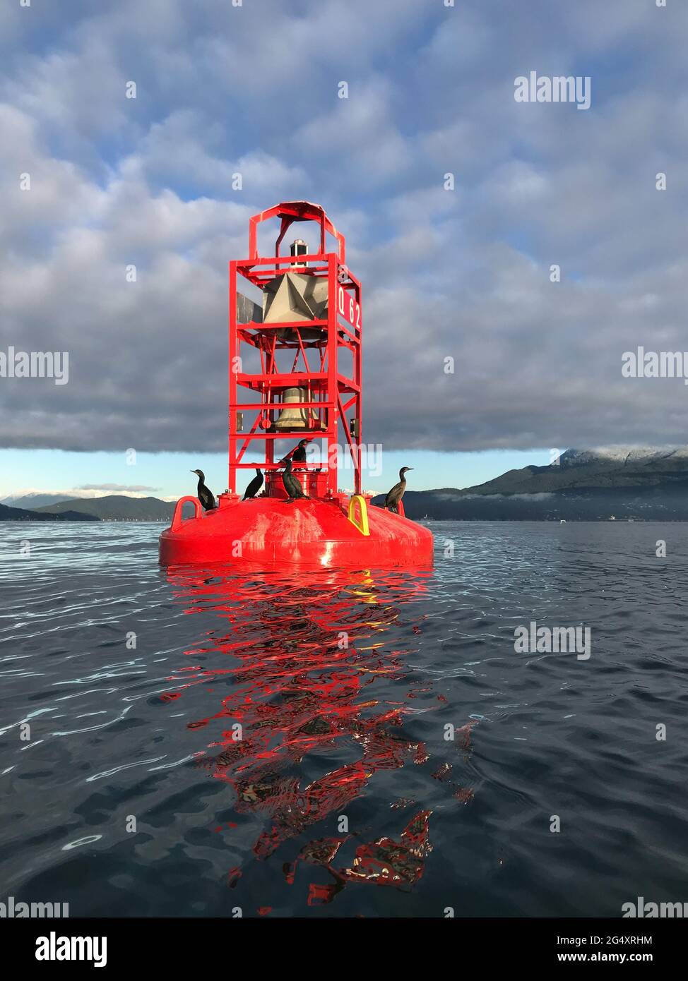 Red Bell buoy canale di spedizione marcatore vicino a riva in oceano Foto Stock