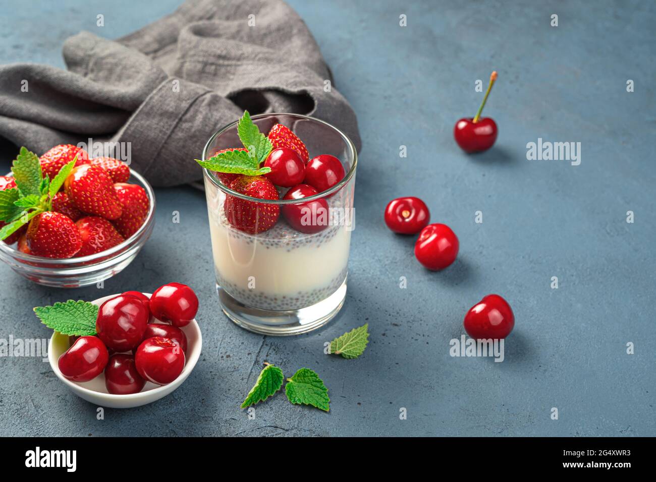 Un dessert sano con semi di chia e frutti freschi e frutti su sfondo scuro. Foto Stock