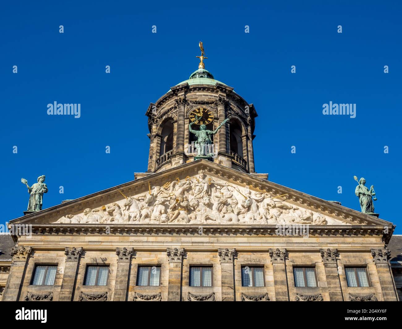 La facciata del Palazzo reale in Piazza Dam, Amsterdam, costruito come municipio durante l'età dell'oro olandese nel XVII secolo, sotto il cielo blu Foto Stock