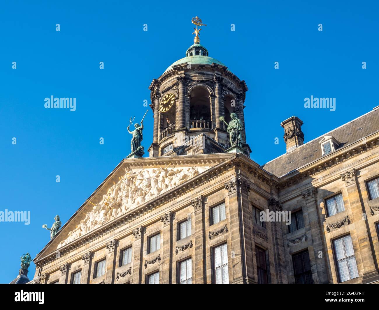 La facciata del Palazzo reale in Piazza Dam, Amsterdam, costruito come municipio durante l'età dell'oro olandese nel XVII secolo, sotto il cielo blu Foto Stock
