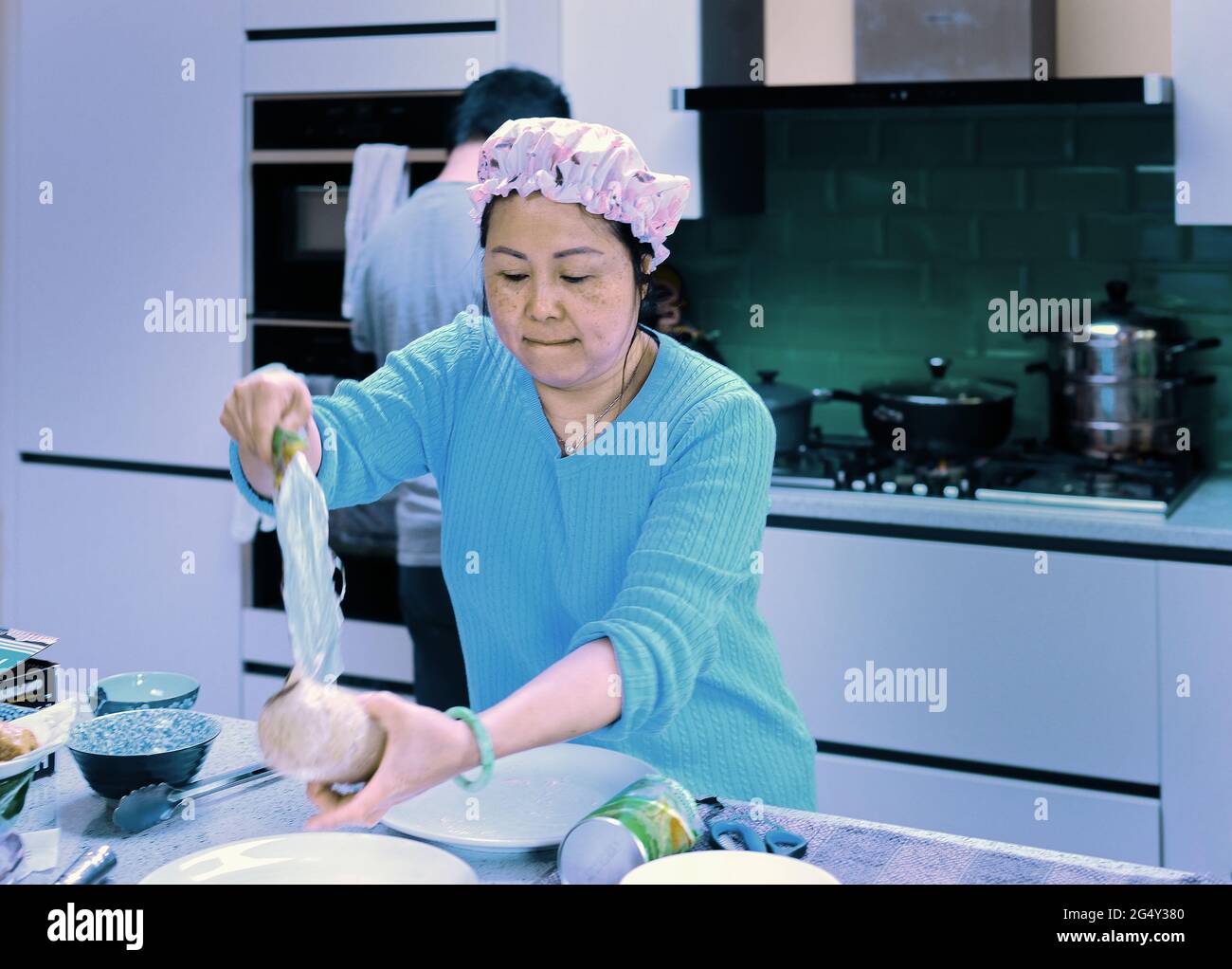Donna cinese che prepara un pasto a casa Foto Stock