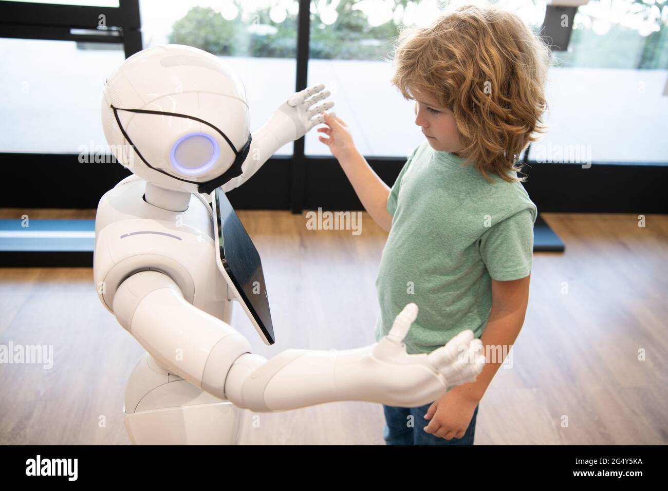 futuro pandemico robotico. il robot comunica con il bambino. automazione. tecnologia umanoide Foto Stock