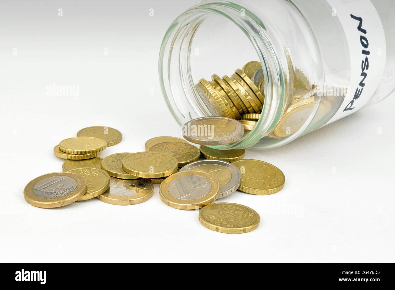 Un vasetto di marmellata pieno di monete in euro in sterline che fuoriescono da un vasetto di risparmio pensionistico. Foto Stock