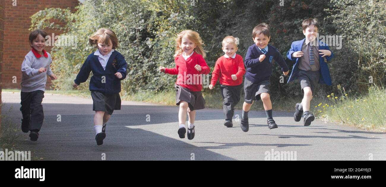 Bambini piccoli che indossano varie uniformi scolastiche Foto Stock