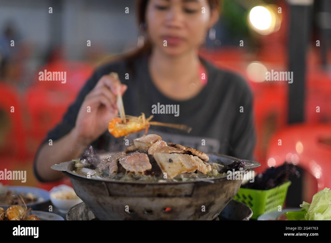 Graziose donne thailandesi mangiano al tradizionale buffet thailandese - mookata Foto Stock