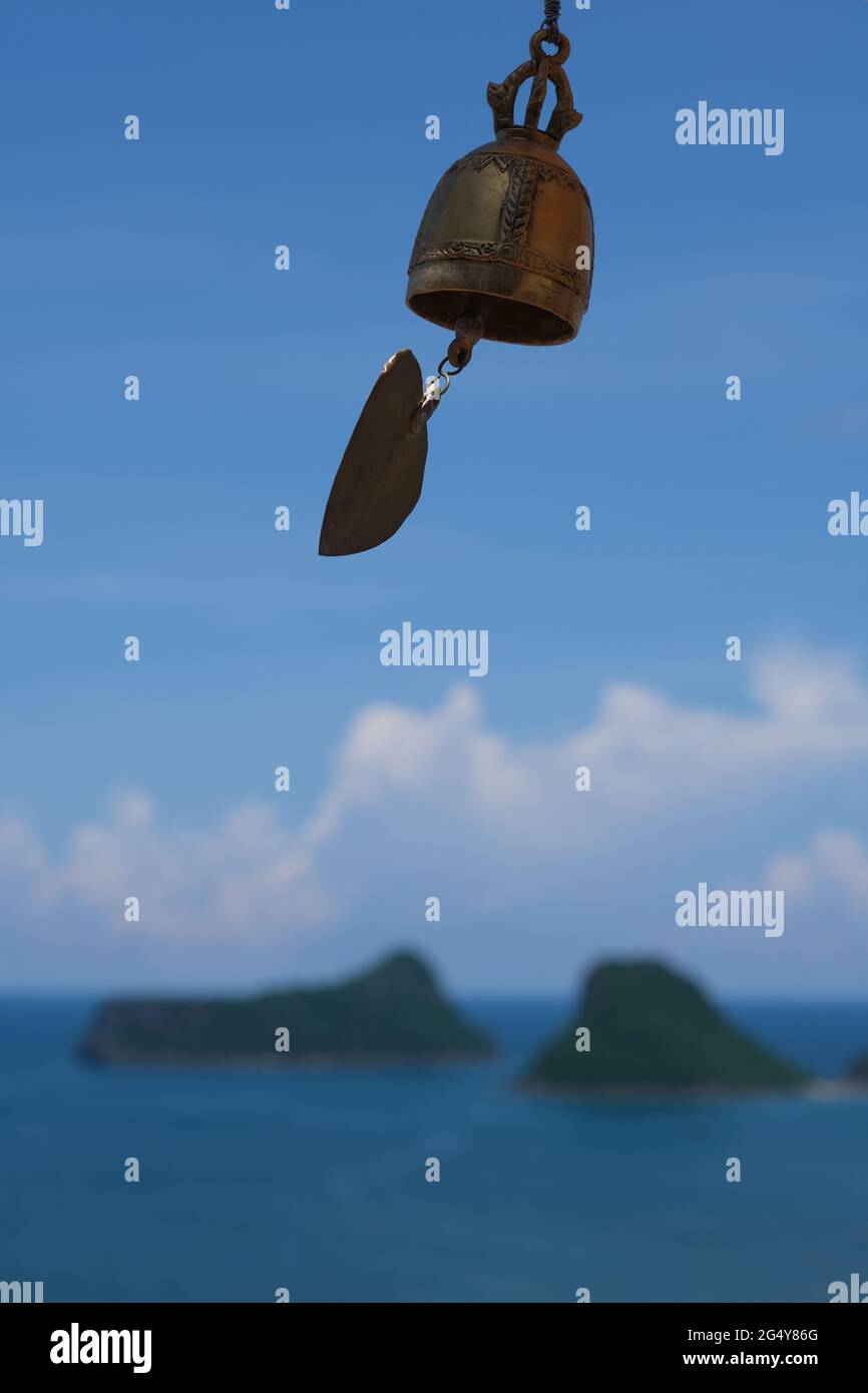 Una piccola campana in un tempio di Buddha, vista sul mare, le isole e le nuvole Foto Stock
