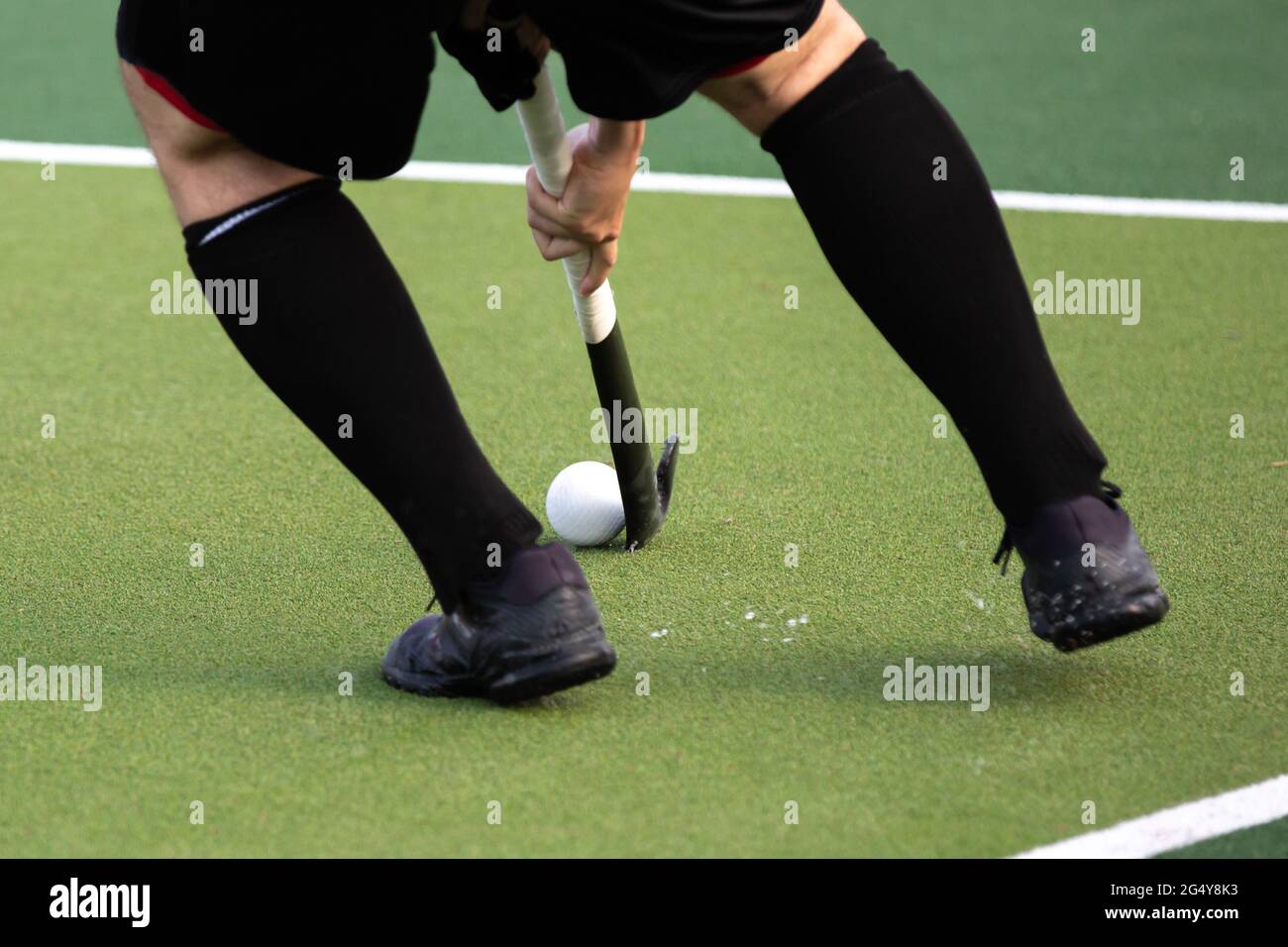 Giocatore di hockey su campo su campo di gioco erba artificiale. Foto Stock