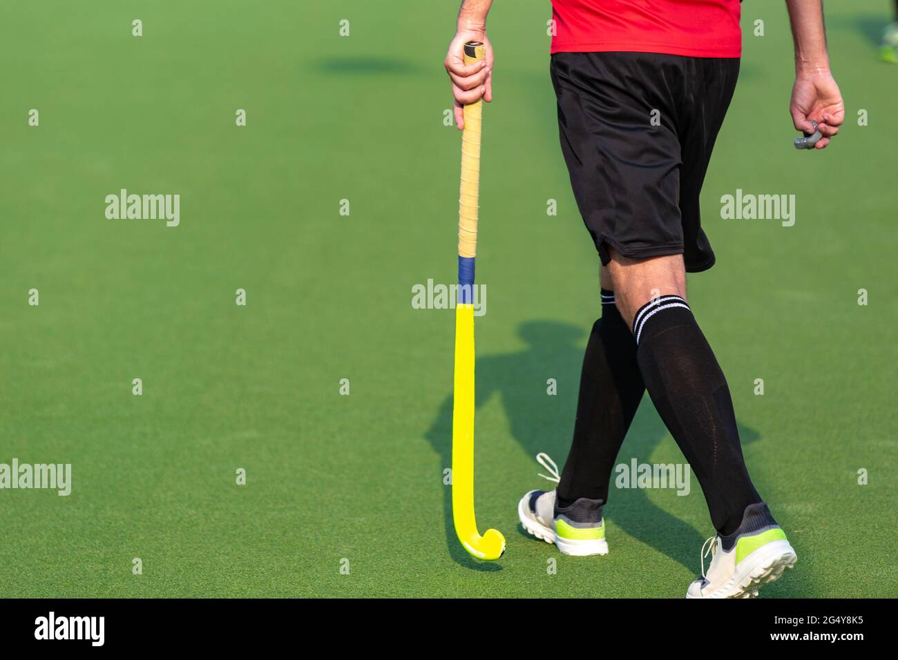 Giocatore di hockey su campo su campo di gioco erba artificiale. Foto Stock