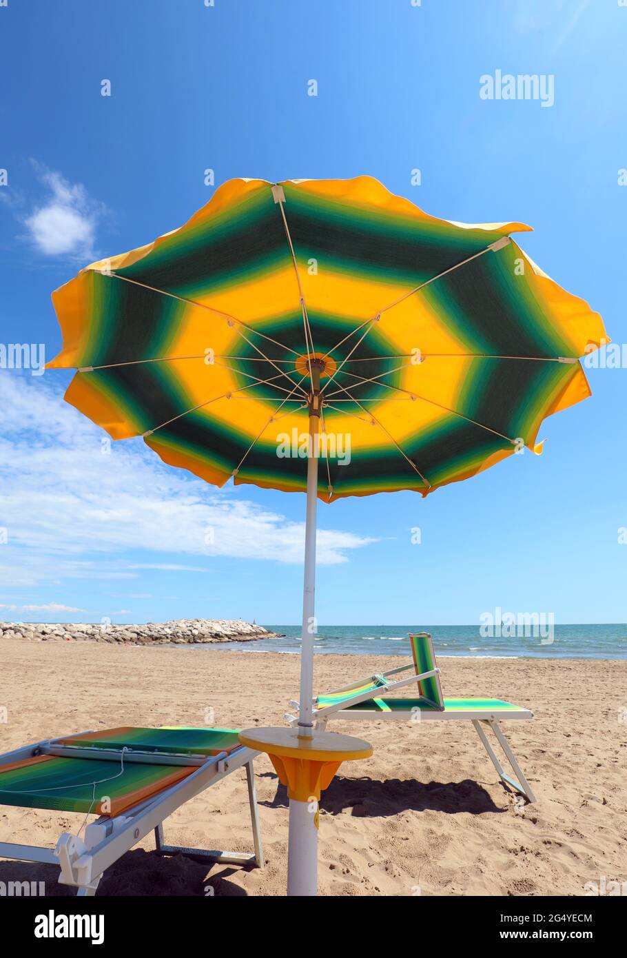 sotto un grande ombrellone e sedie a sdraio vicino al mare, in estate  simbolo di relax e vacanze estive Foto stock - Alamy