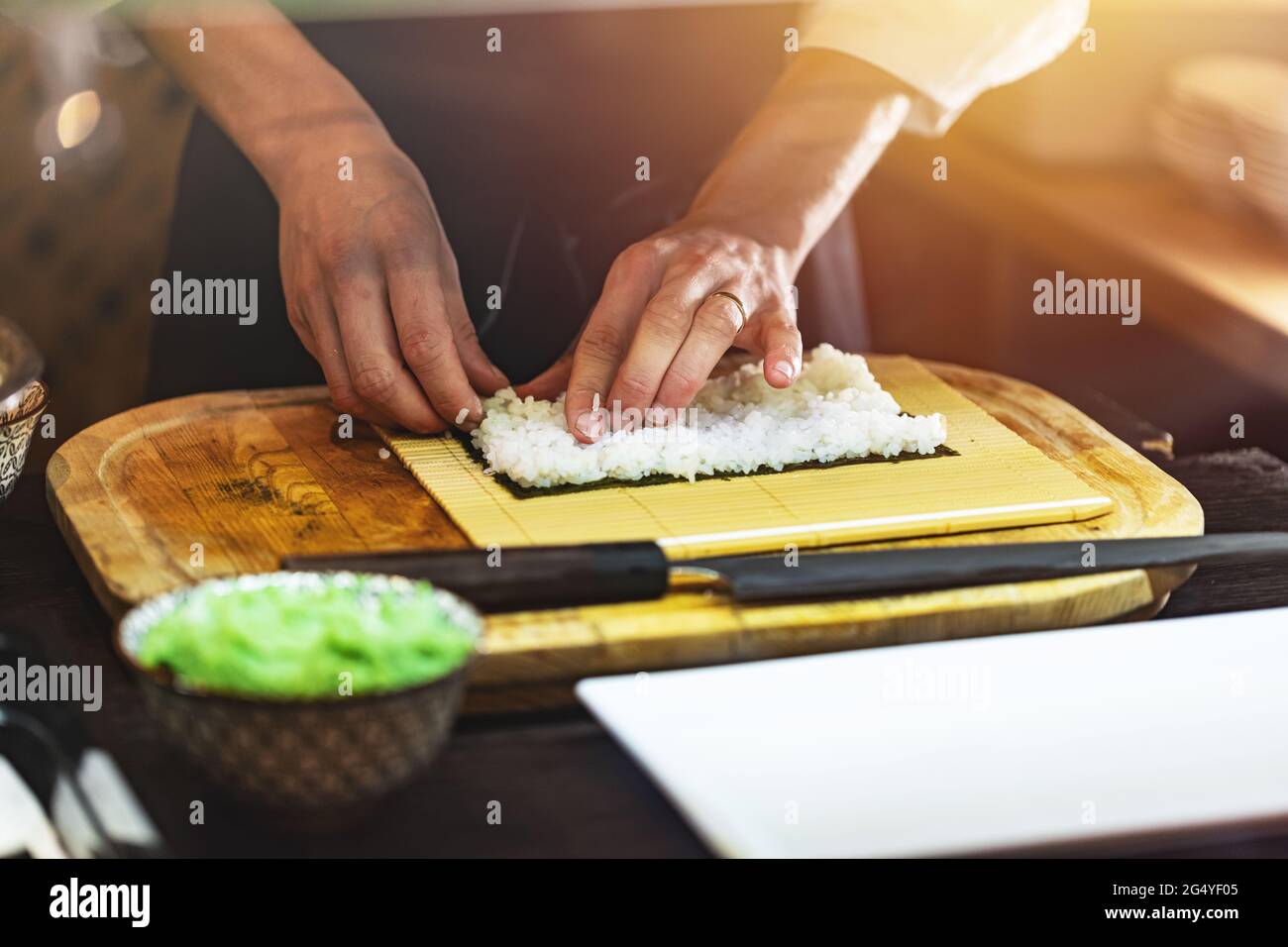 Chef che prepara panini di sushi giapponesi. Processo di produzione del sushi Foto Stock