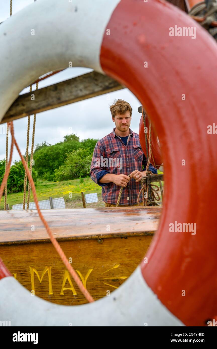 Ed Gransden è uno dei skipper su 'Edith May', una storica chiatta a vela, vista attraverso una vita boa. Lower Halstow, Kent, Inghilterra. Foto Stock