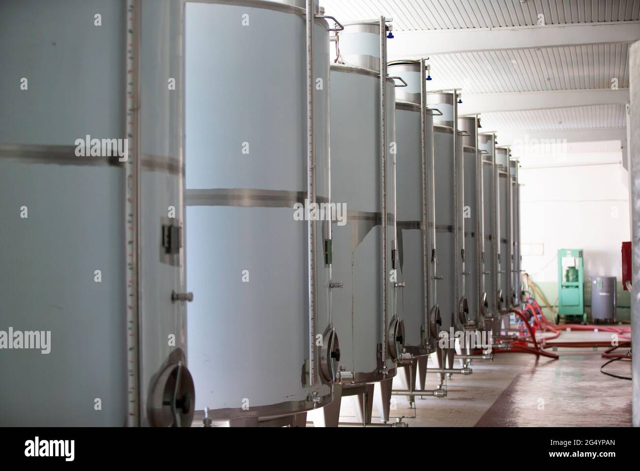Serbatoi industriali in metallo per il vino in un impianto per la produzione di bevande alcoliche. Foto Stock