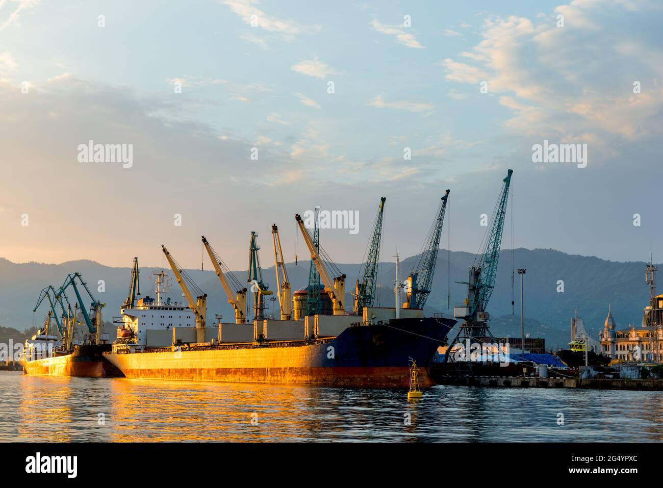 Vista delle gru di carico nel porto al tramonto, Batumi, Georgia Foto Stock