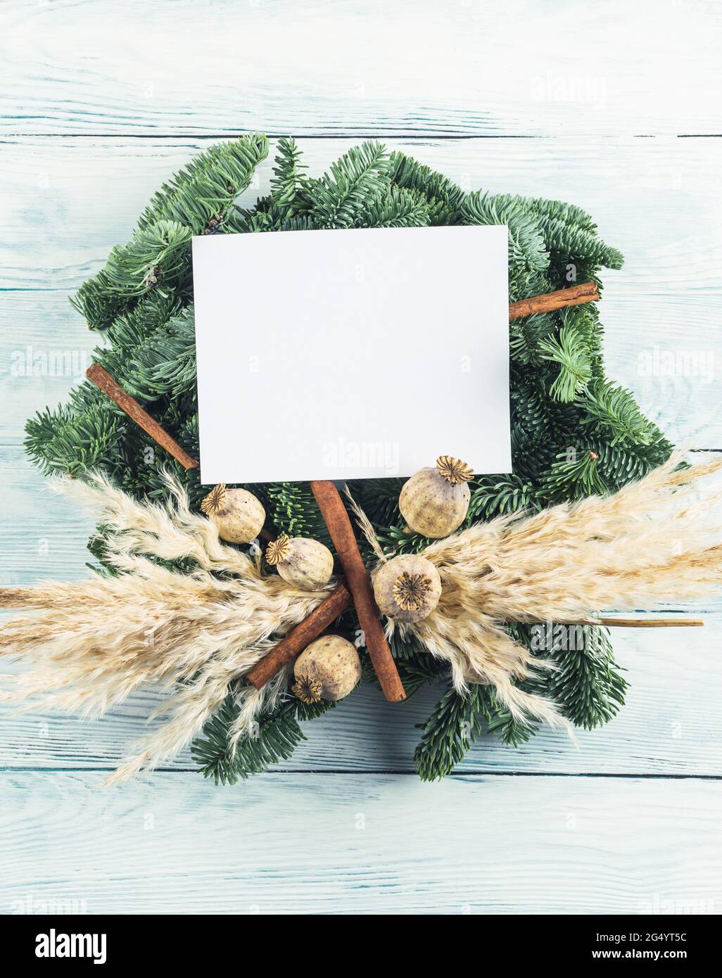Naturale natale abete rosso ardesia decorazione wreath con vuoto biglietto d'auguri su sfondo di legno Foto Stock