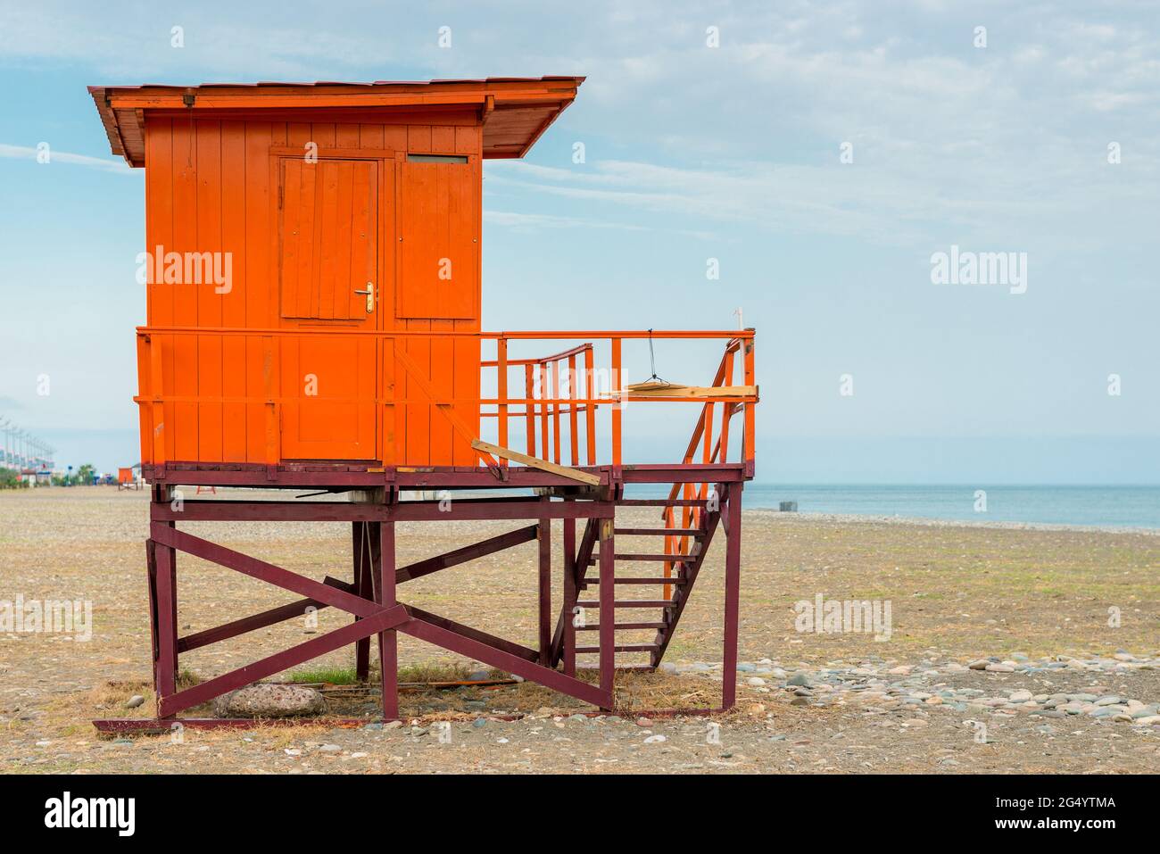 Torre di soccorso rossa su una spiaggia vuota al mattino presto Foto Stock