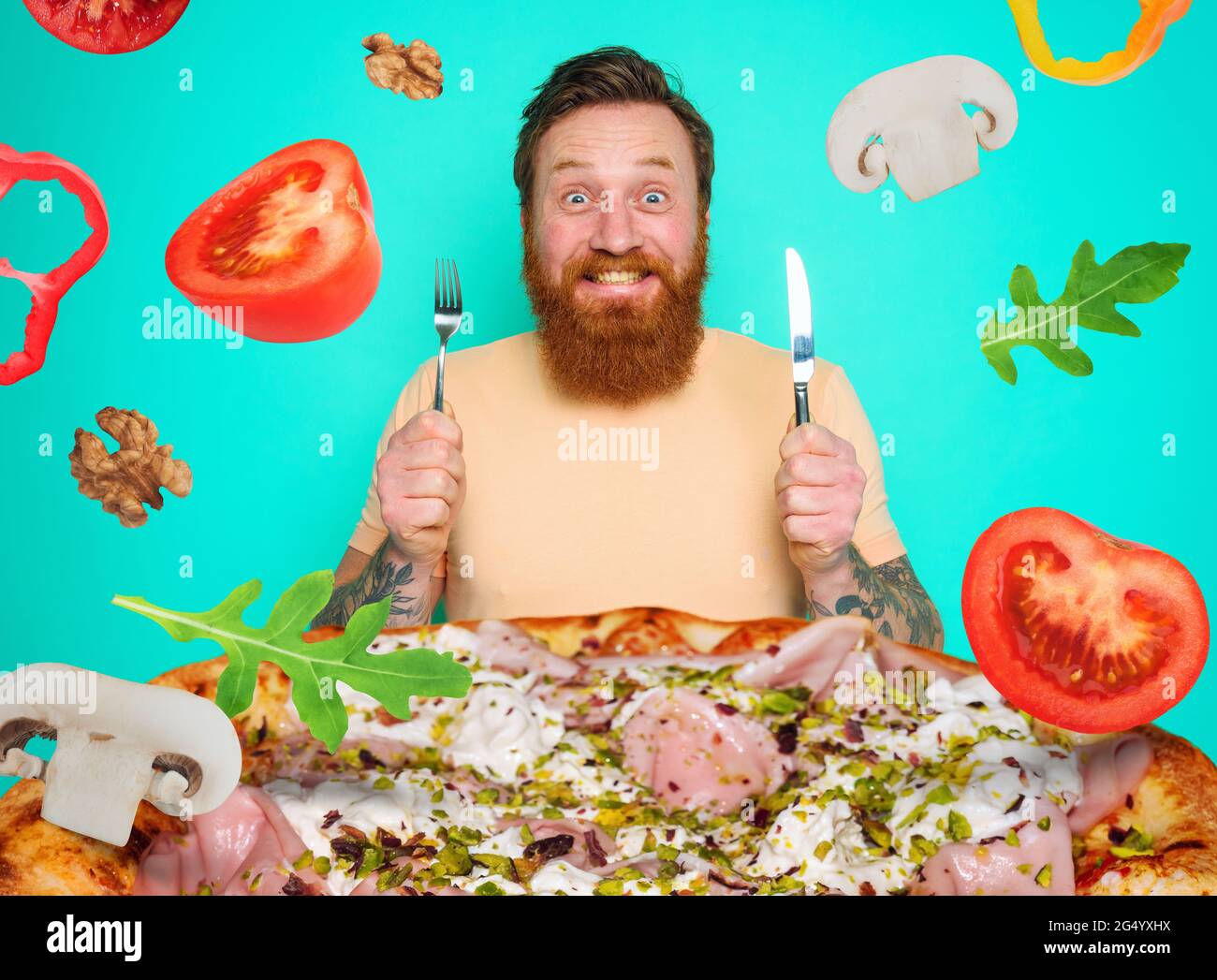 L'uomo con barba e tatuaggi è pronto a mangiare una pizza grande Foto Stock