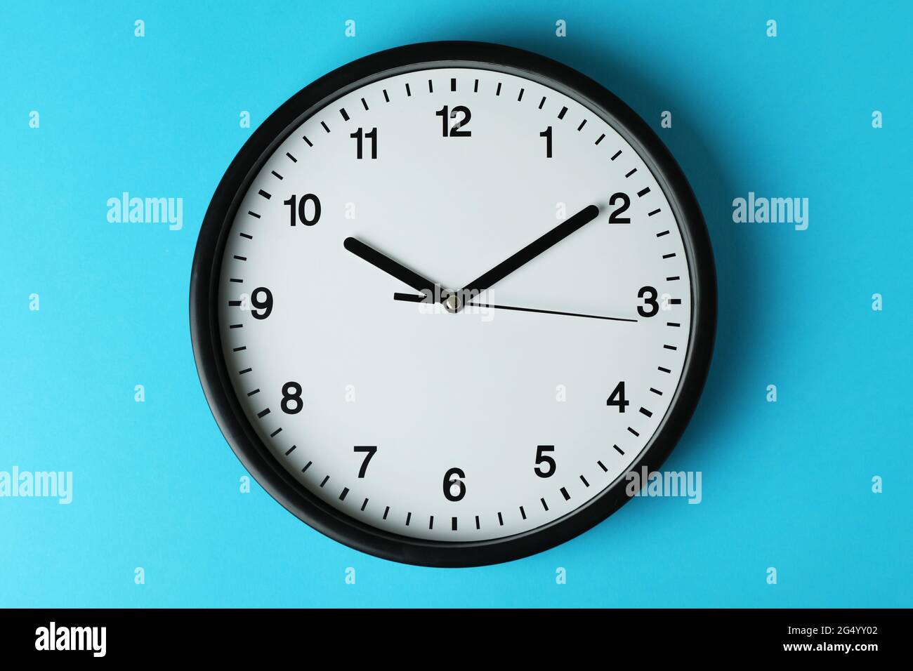 Orologio da ufficio nero standard su sfondo blu Foto Stock