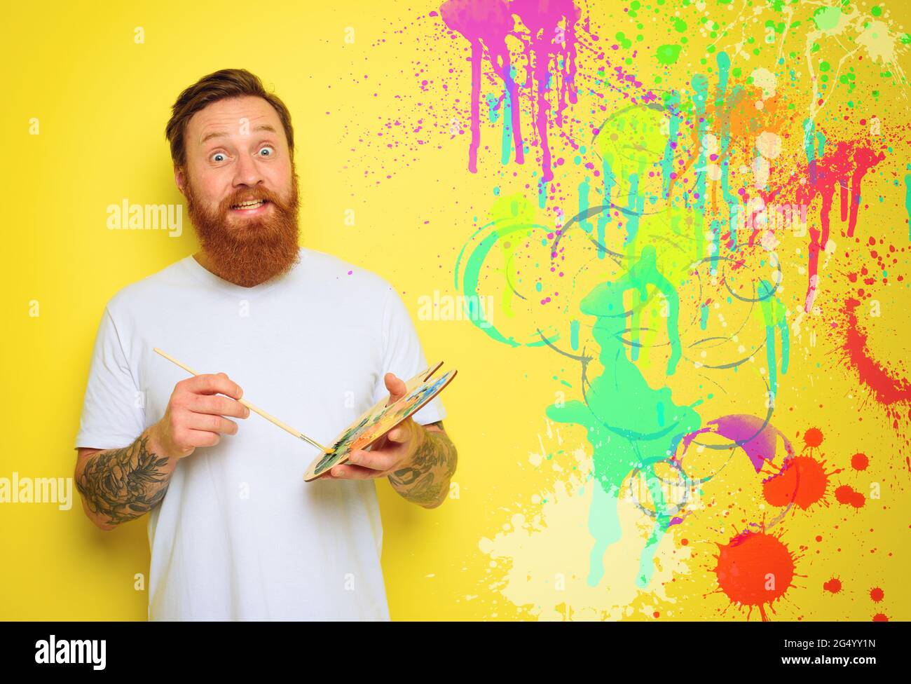 L'uomo doubter con barba e tatuaggio è pronto a disegnare con le spazzole Foto Stock