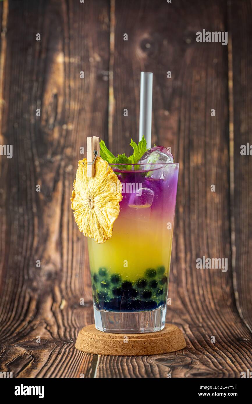 Tè fruttato Bubble in una tazza di vetro su sfondo di legno Foto Stock