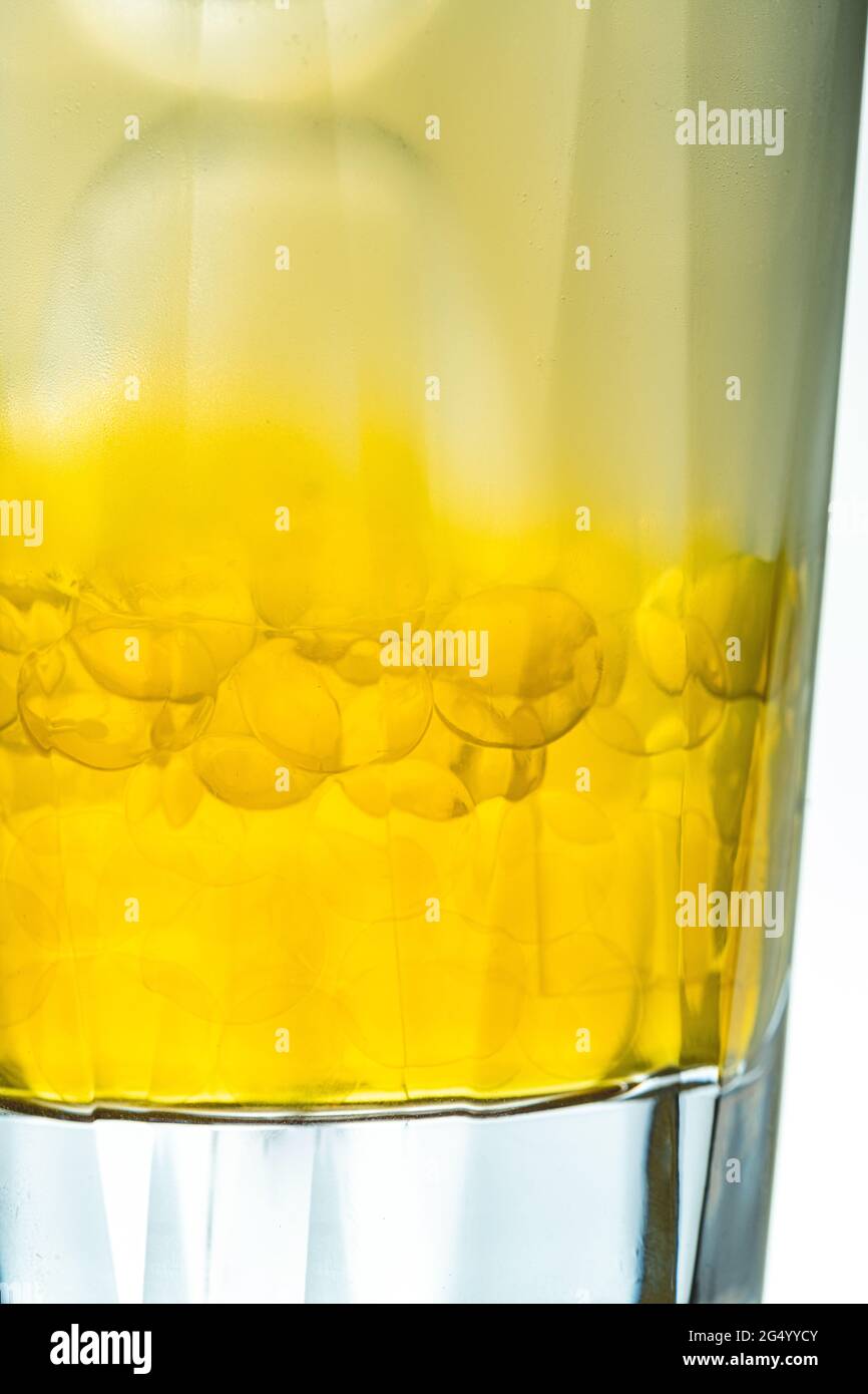 Tè alle bolle fruttato in una tazza di vetro su sfondo blu Foto Stock