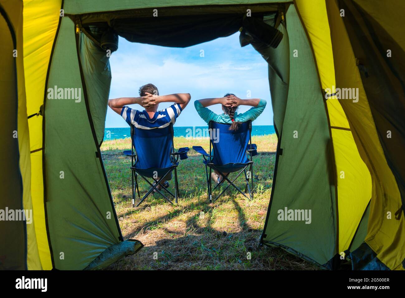 coppia uomo e donna rilassante vicino campeggio tenda sul mare Foto Stock