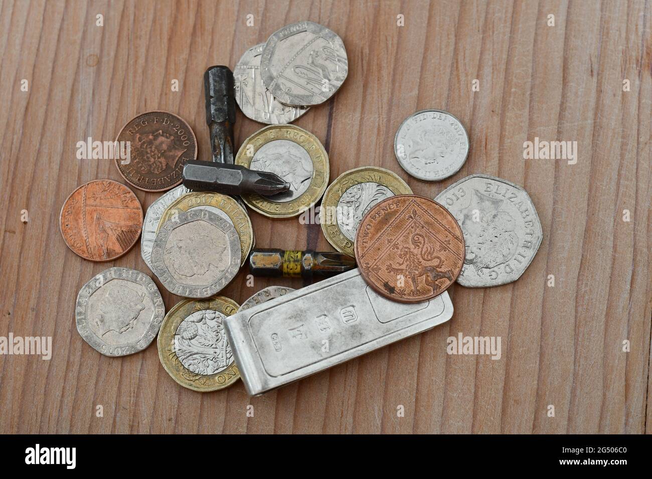 Una pila di monete britanniche con punte da trapano e una clip in argento sterling, Sterling Foto Stock