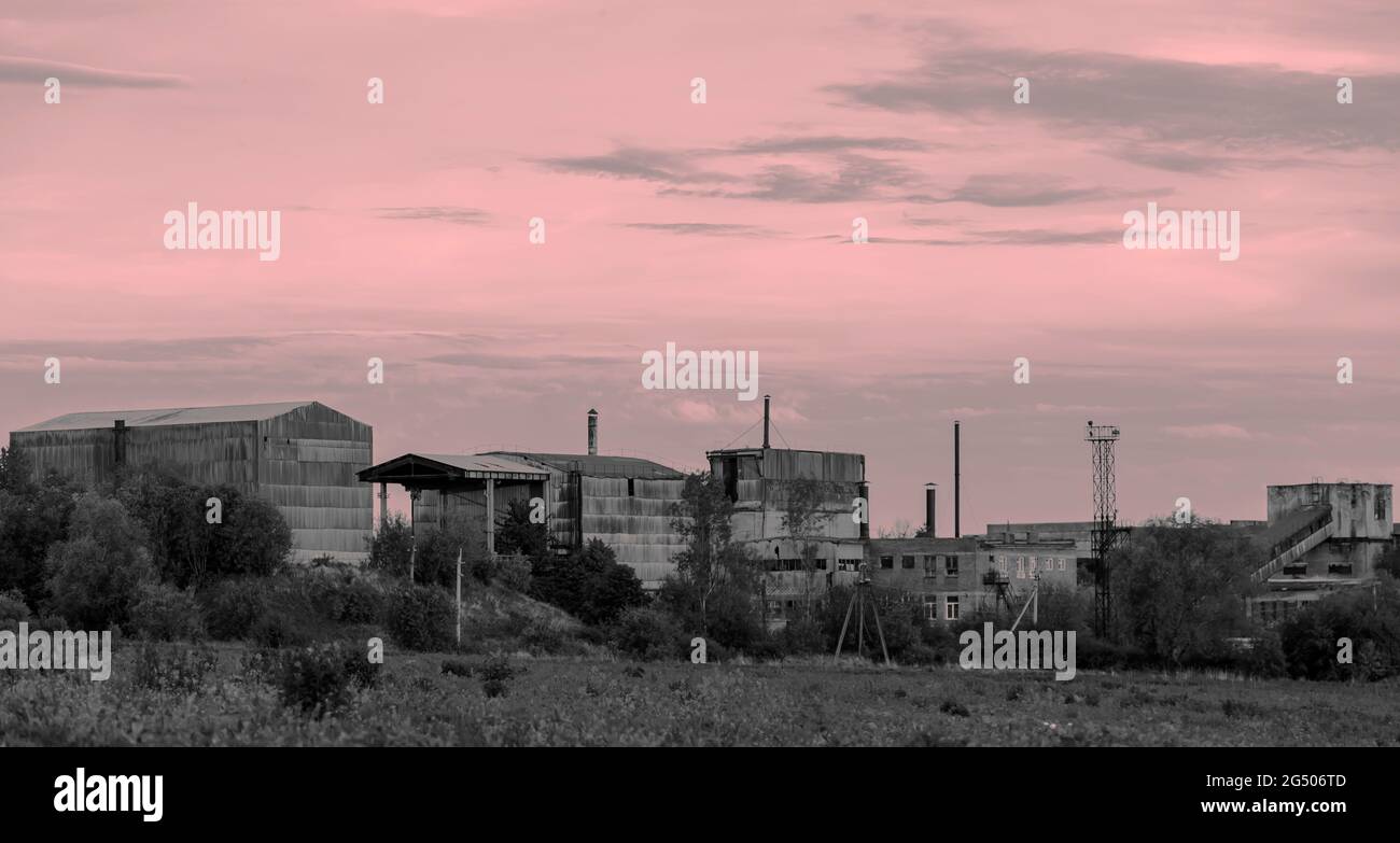 La foto è stata scattata al tramonto. Vecchio edificio. Un impianto industriale in attesa di demolizione. La fabbrica non funziona Foto Stock
