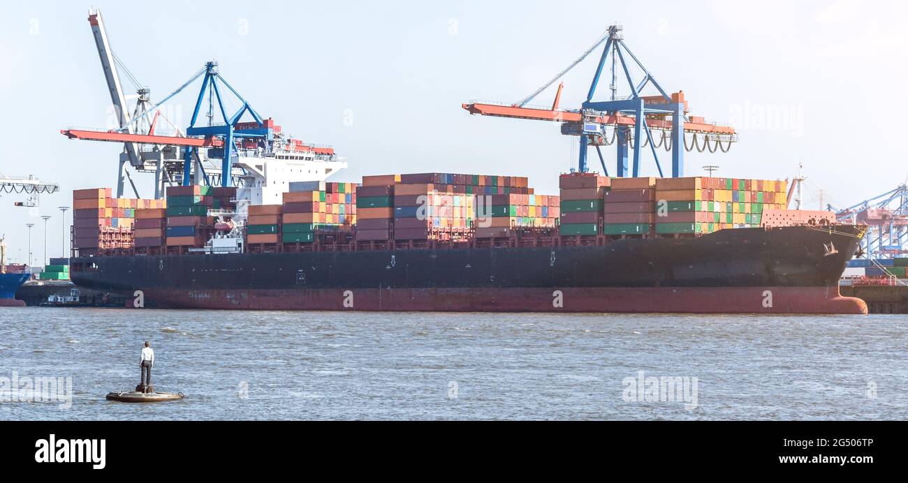 Grande nave container, strutture portuali e famoso statuto di nuoto a Övelgönne ad Amburgo, Germania Foto Stock