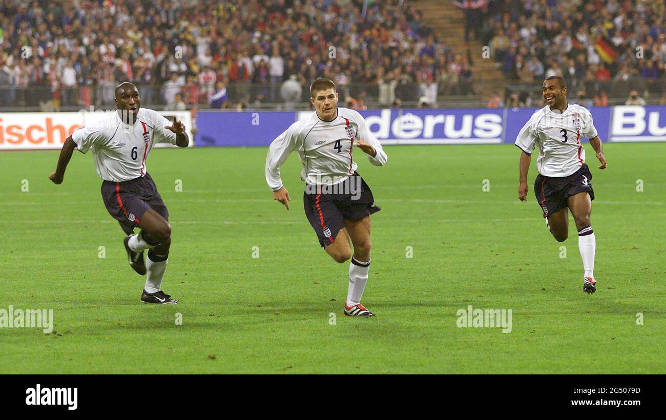 FILE : 24 GIUGNO 2021. LA GERMANIA SUONERÀ IN INGHILTERRA IL 29 GIUGNO 2021 PER LA UEFA EURO 2020. LA FOTO ORIGINALE È STATA SCATTATA IL 1 SETTEMBRE 2001 STEVEN GERRARD CELEBRA IL SUO OBIETTIVO CON SOL CAMPBELL E ASHLEY COLE GERMANIA / INGHILTERRA - QUALIFICATORE MONDIALE DI COPPA, MONACO. IMMAGINE 1/09/2001 : MARK PAIN / ALAMY Foto Stock