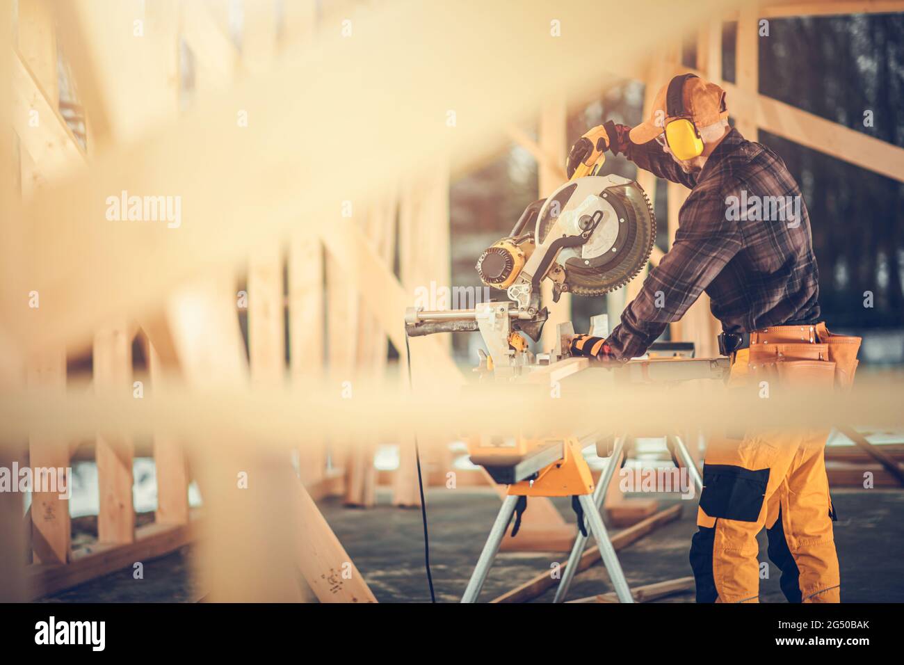 Costruzione di scheletro di Casa di legno usando sega potente di legno. Contraente di costruzione che usa gli attrezzi di alimentazione all'interno del telaio di legno della costruzione della costruzione della costruzione di nuovo Foto Stock