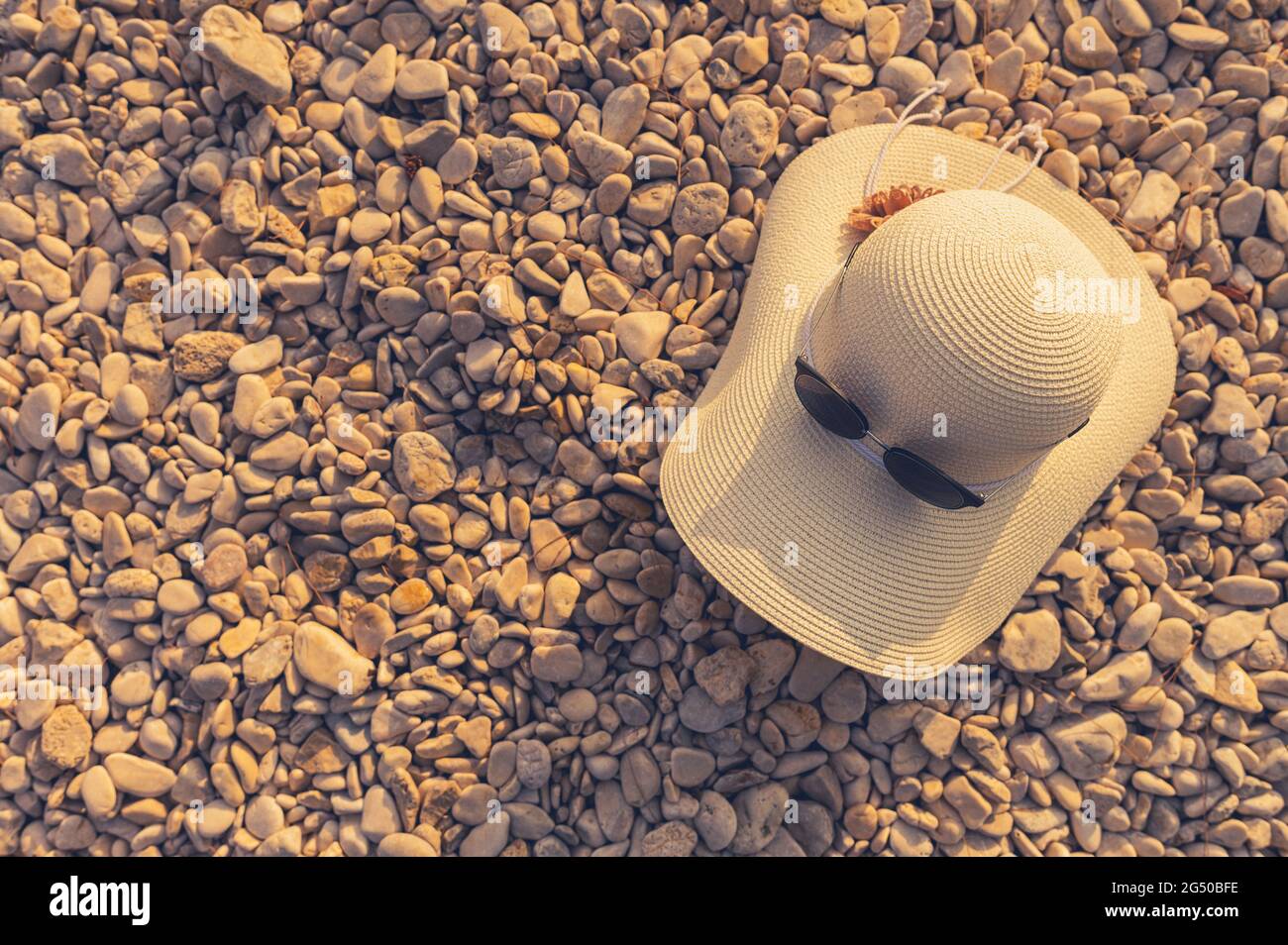 Cappello di sole e occhiali da sole su un tema di vacanza di Rocky Beach. Foto Stock