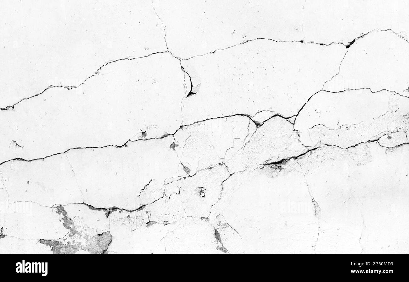 Trama di fondo di una parete bianca grugnosa con strato danneggiato di vernice e crepe Foto Stock