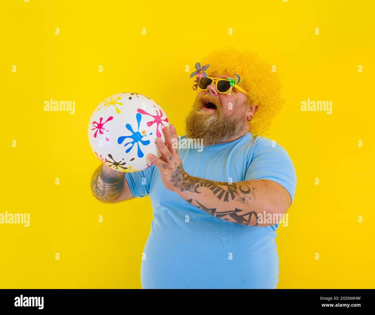 Uomo grasso con parrucca in testa e occhiali da sole si divertono con una  palla Foto stock - Alamy